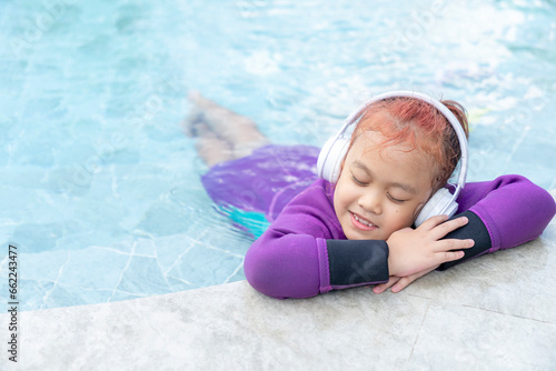 Happy little girl listening to music at pool #662243477