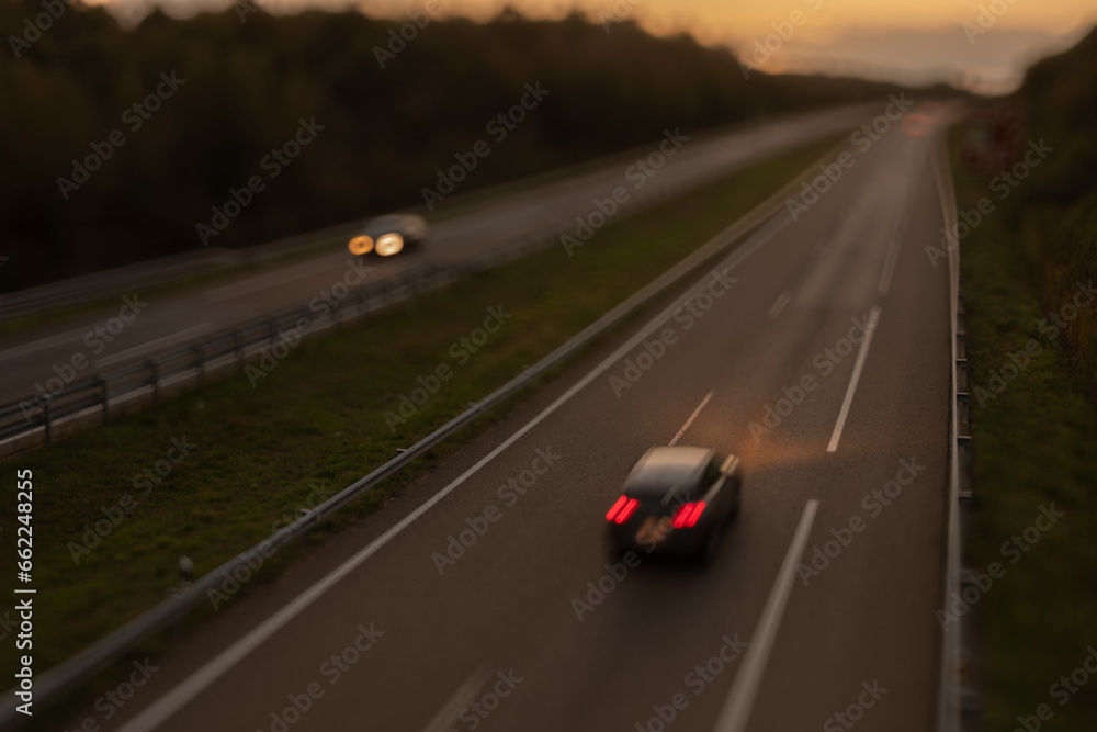 Blurred photography of cars motion in a highway at sunset