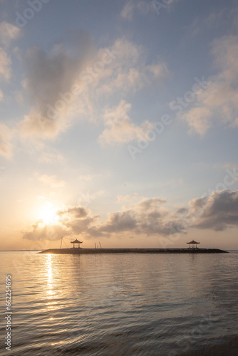 Landscape shot in Bali. Sunrise or sunset at Sanur beach. Beautiful sandy beach in the morning  with fine sand and a view of the calm sea. Temples are in the water. A dream in Indonesia