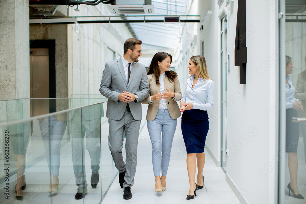 Young startup team have a discussion while walking in the modern office corridor Young startup team have a discussion while walking in the modern office corridor