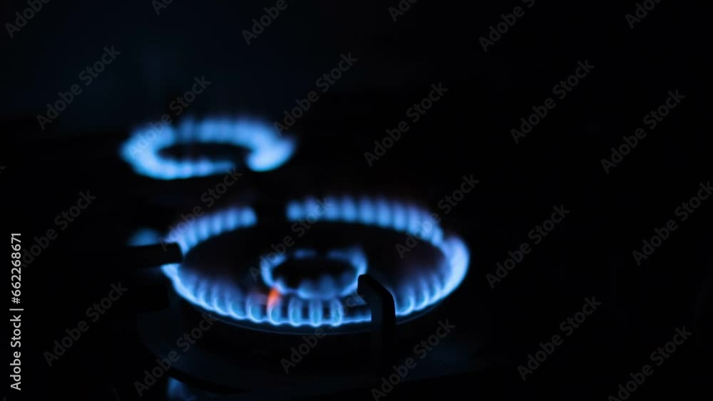 Lighting a fire on a kitchen gas stove. A close-up of the burning flame of the burner. Light the gas blue flame. Lighting a fire on a kitchen gas stove. A close-up of the burning flame of the burner. Light the gas blue flame.