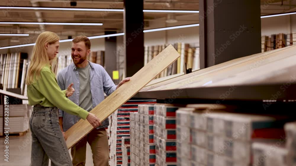 Couple choosing laminate for floor at building market Couple choosing laminate for floor at building market