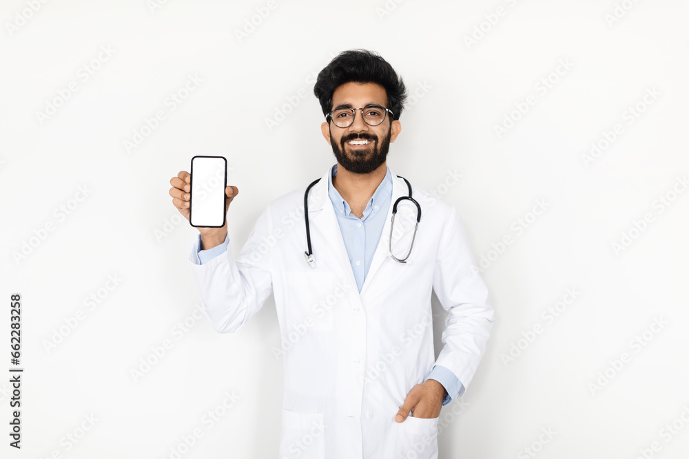 Indian Doctor Presenting Smartphone with Blank Screen Indian Doctor Presenting Smartphone with Blank Screen