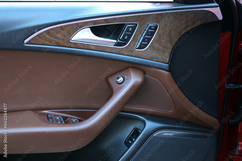 Premium Car door wooden trim with windows control. Lux Car Inside Door Handle Interior. Door wooden trim. Front door wooden trim of a Prestige car. Modern Car interior. 