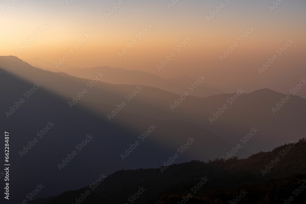 Stunning landscape view of a colorful sky and majestic mountains illuminated by a light Stunning landscape view of a colorful sky and majestic mountains illuminated by a light