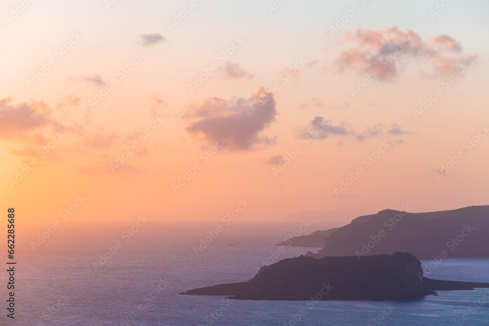 Pink foggy sunset at Santorini island, Greece. View of the sea and islands.