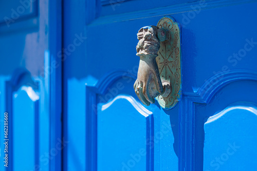 Blue-painted wooden door with antique metal handle. Santorini, Greece