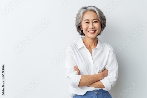 Portrait of Asian senior woman posing on white wall background. photo