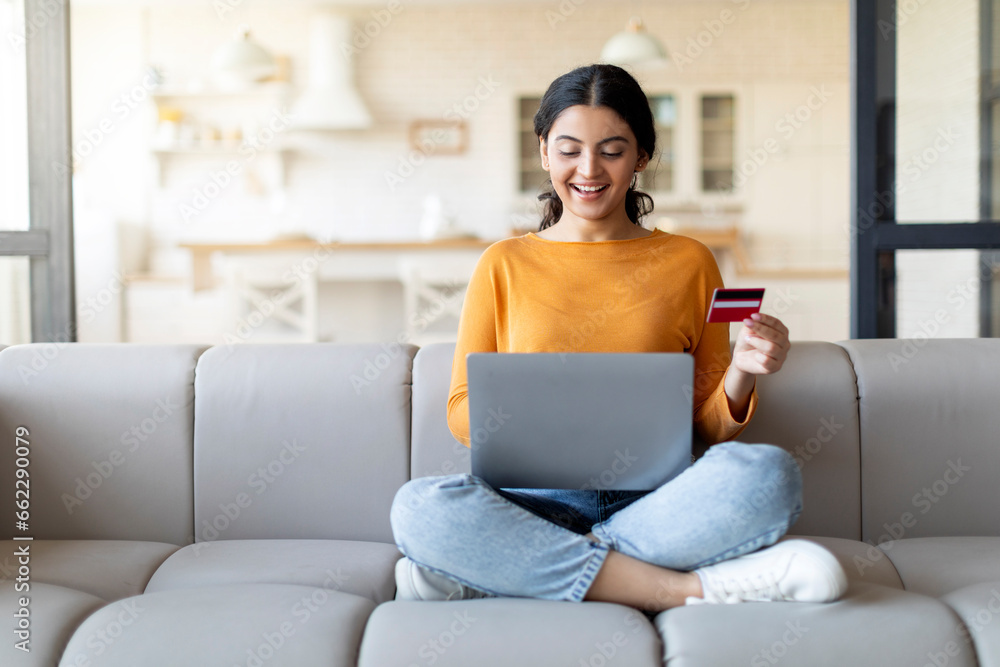 Smiling Young Indian Woman Making Online Shopping With Laptop And Credit Card