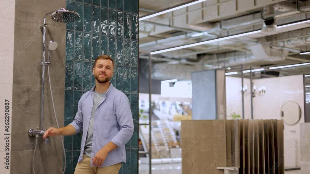 Man at the building market choosing shower for his bathroom Man at the building market choosing shower for his bathroom