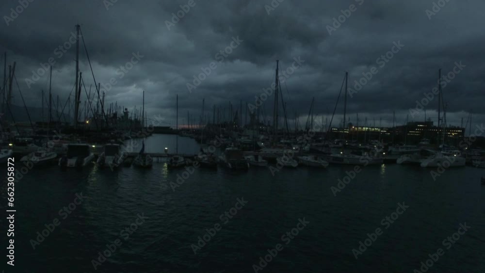 Dark, harbor and boats at sea for travel, vacation or adventure at night. Evening, water and landscape or aerial view of yacht or sailing transport at a port for a holiday during a storm or winter Dark, harbor and boats at sea for travel, vacation or adventure at night. Evening, water and landscape or aerial view of yacht or sailing transport at a port for a holiday during a storm or winter
