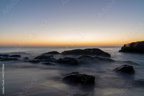 Ocean waves crash at a Pacific Ocean sunset © FATIR29