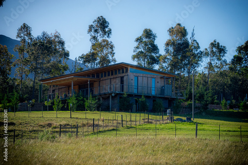 Rustic Stilted Retreat: Wooden House Amidst Lush Hills and Majestic Mountains