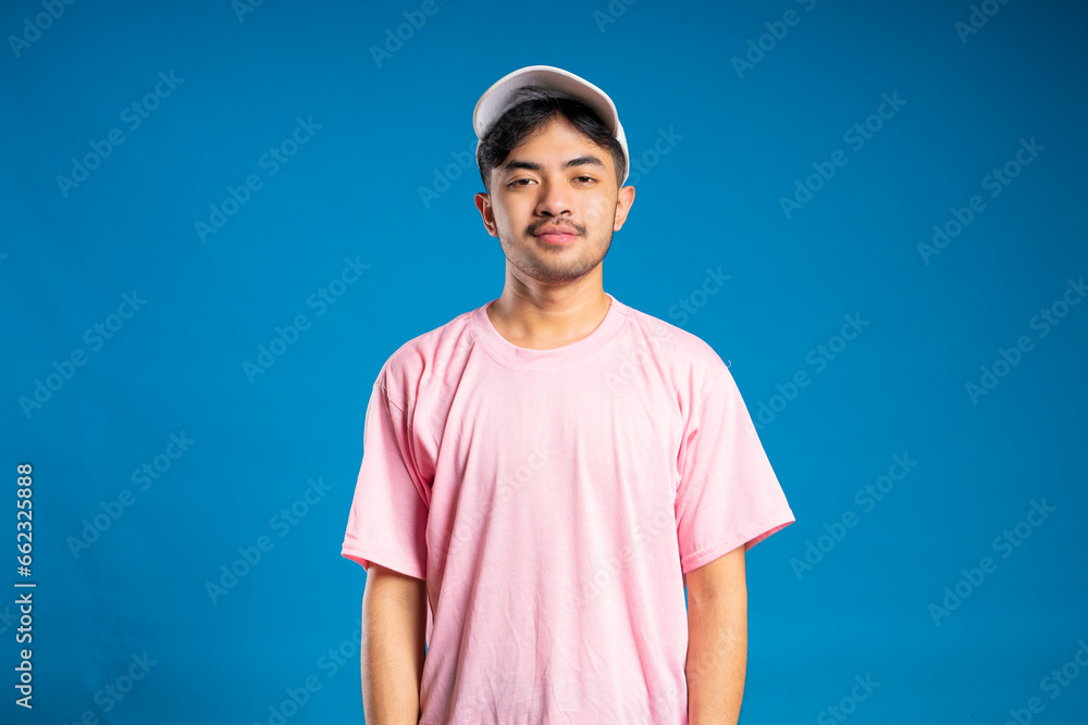 Handsome positive dark skinned unshaven man makes triumph dance raises fists has fun on party expresses happy emotions smiles broadly wears casual pink t shirt isolated over grey background. Handsome positive dark skinned unshaven man makes triumph dance raises fists has fun on party expresses happy emotions smiles broadly wears casual pink t shirt isolated over grey background.