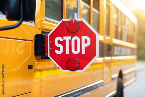 Closeup shot of extended red stop sign on yellow school bus