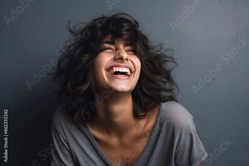 Young middle eastern woman laughing looking at the camera studio shot
