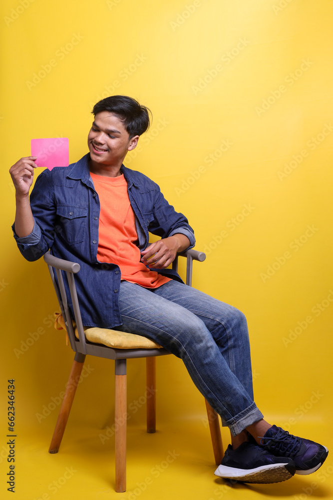 Full length photo of optimistic guy wear casual clothes hold smartphone and comment shape for social media advertisement Full length photo of optimistic guy wear casual clothes hold smartphone and comment shape for social media advertisement