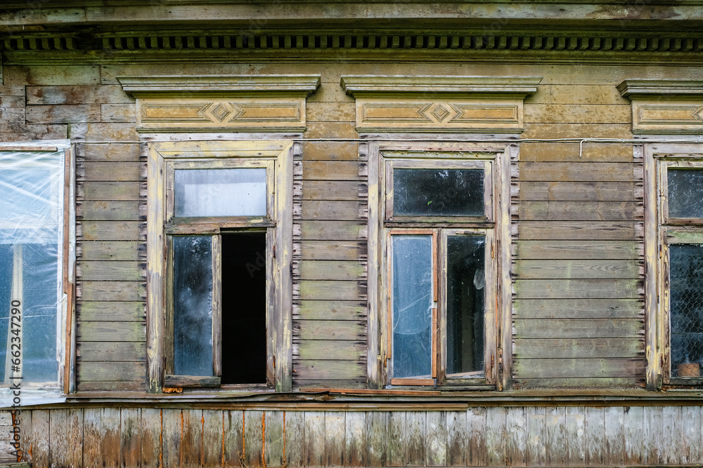 An old, abandoned, vandalized wooden house. Wooden architecture, desolation, loneliness.