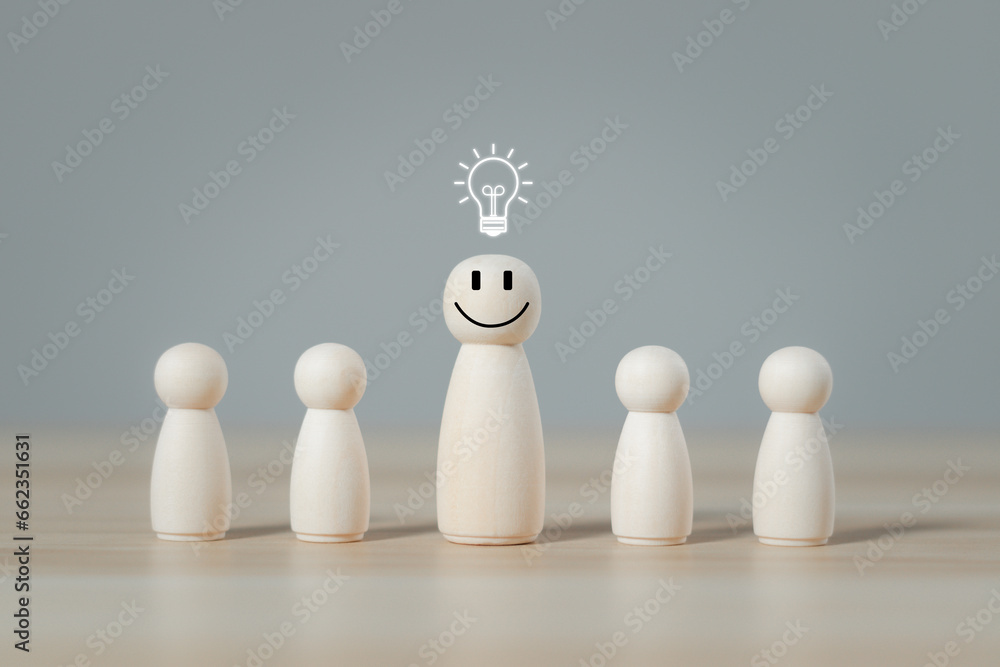 Human resource management and leadership skills. Business team building, wooden figures smile face with light bulb icon for great idea and inspiration for creativity and innovation from brainstorming.