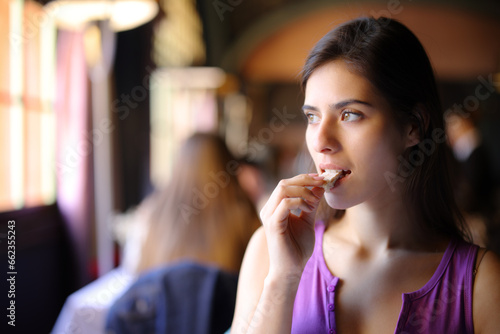 Beautiful customer eating bread in a restaurant