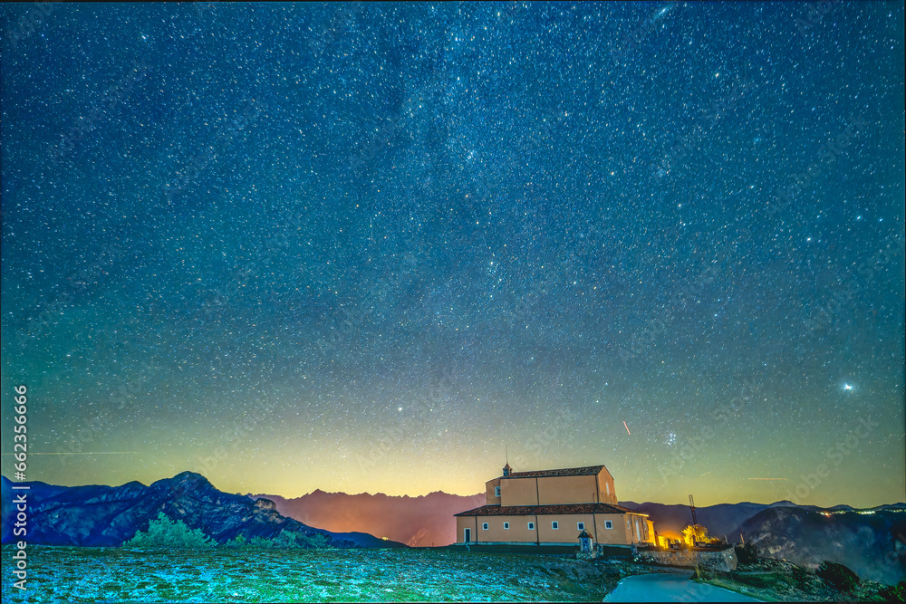 Un beau ciel étoilé avec la queue de la voie lactée au dessus de l'église de la Madone d'Utelle dans les Alpes du Sud - obrazy, fototapety, plakaty 