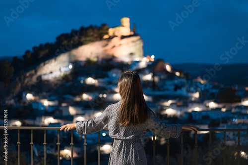 Woman in travel, Asian woman in blue dress looking at the old city of Montefrío at night in Granada, Spain photo