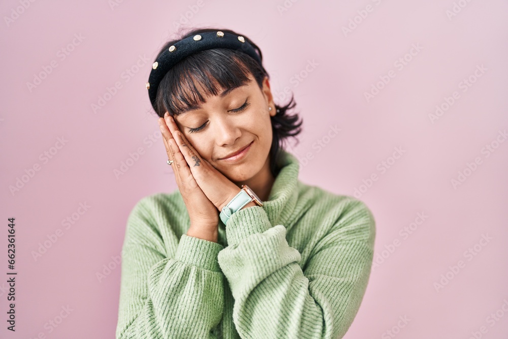 Young beautiful woman standing over pink background sleeping tired dreaming and posing with hands together while smiling with closed eyes. Young beautiful woman standing over pink background sleeping tired dreaming and posing with hands together while smiling with closed eyes.