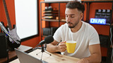 Young arab man musical reporter speaking on radio show drinking coffee radio studio