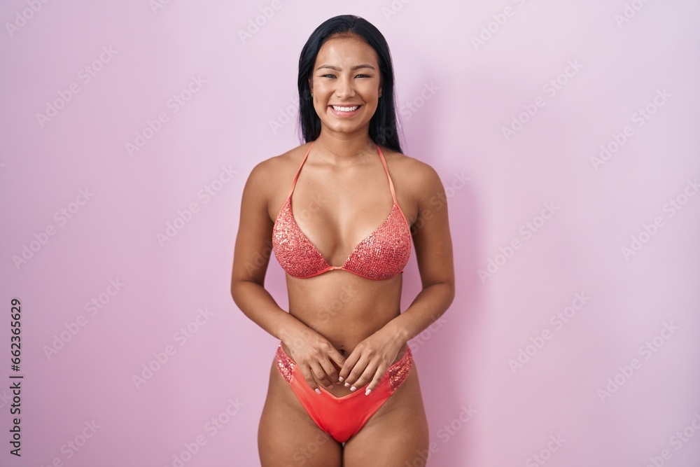 Hispanic woman wearing bikini with a happy and cool smile on face. lucky person. Hispanic woman wearing bikini with a happy and cool smile on face. lucky person.