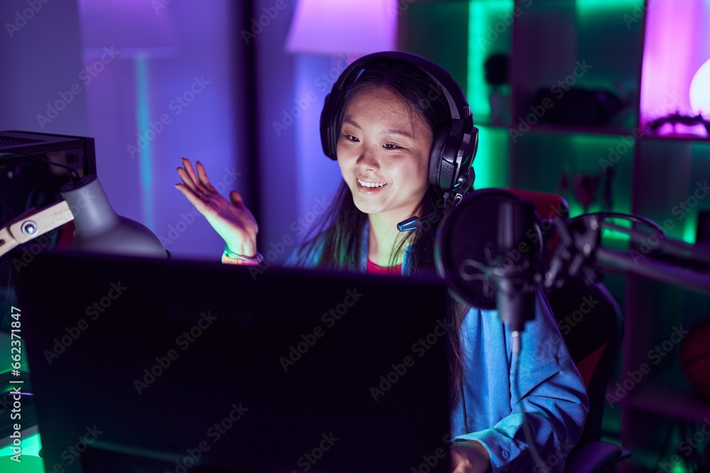 Young asian woman playing video games celebrating achievement with happy smile and winner expression with raised hand Young asian woman playing video games celebrating achievement with happy smile and winner expression with raised hand