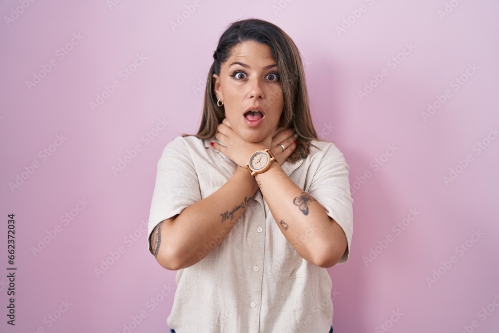 Blonde woman standing over pink background shouting suffocate because painful strangle. health problem. asphyxiate and suicide concept. Blonde woman standing over pink background shouting suffocate because painful strangle. health problem. asphyxiate and suicide concept.