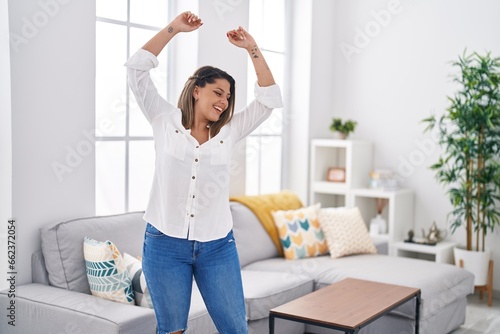 Young hispanic woman smiling confident dancing at home