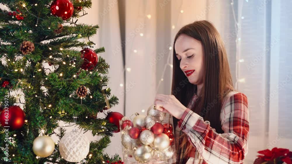 Pretty woman holding transparent box with amazing glass ball for spruce tree branches decoration, winter holiday ornaments for home interior, blinking illumination creating festive atmosphere at home Pretty woman holding transparent box with amazing glass ball for spruce tree branches decoration, winter holiday ornaments for home interior, blinking illumination creating festive atmosphere at home