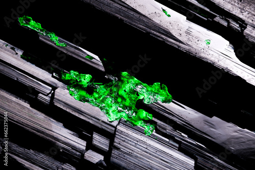 hyalite opal crystal (green under short wave UV)  on schorl (black tourmaline). macro detail texture background. close-up raw rough unpolished semi-precious gemstone
 photo