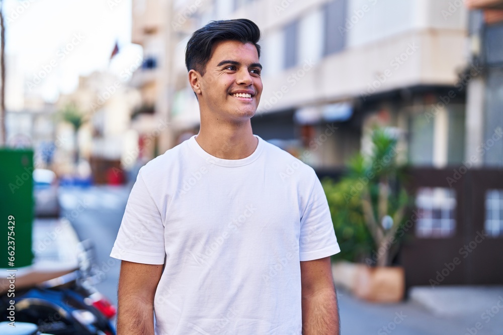 Fototapeta premium Young hispanic man smiling confident looking to the side at street