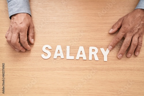 Middle age grey-haired man business worker sitting on table with salary word at office photo