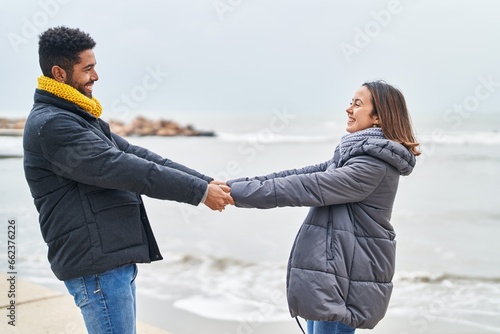 Man and woman couple smiling confident dancing at seaside