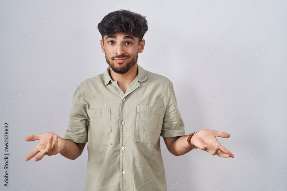 Arab man with beard standing over white background clueless and confused with open arms, no idea concept. Arab man with beard standing over white background clueless and confused with open arms, no idea concept.