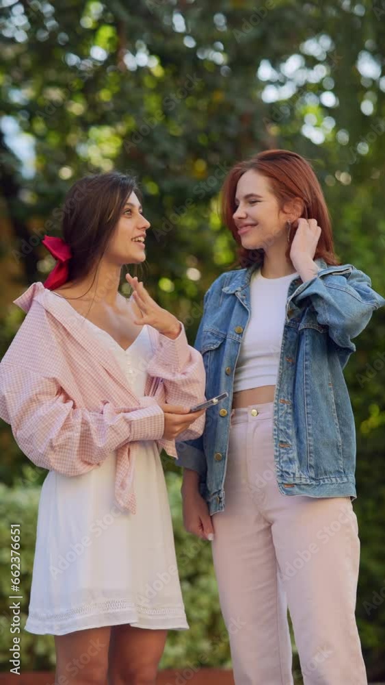 Two fashionable and elegant girls deep in conversation on the streets. Two fashionable and elegant girls deep in conversation on the streets.