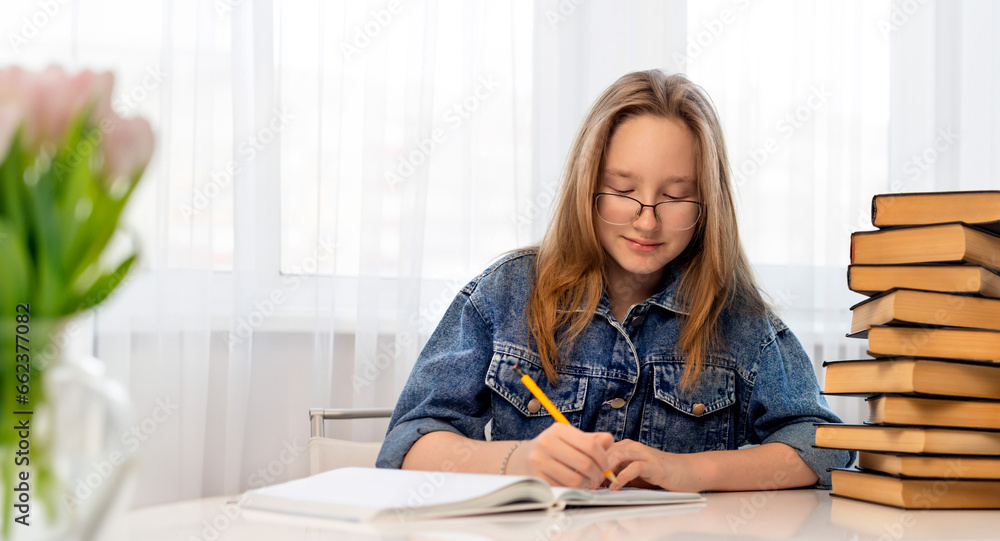 A girl with loose hair draws in a notebook. A girl with loose hair draws in a notebook.