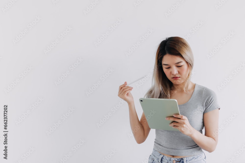 Asian Thai woman thinking something, hands holding tablet and white pen, got idea while working hard, isolated on white background. Asian Thai woman thinking something, hands holding tablet and white pen, got idea while working hard, isolated on white background.