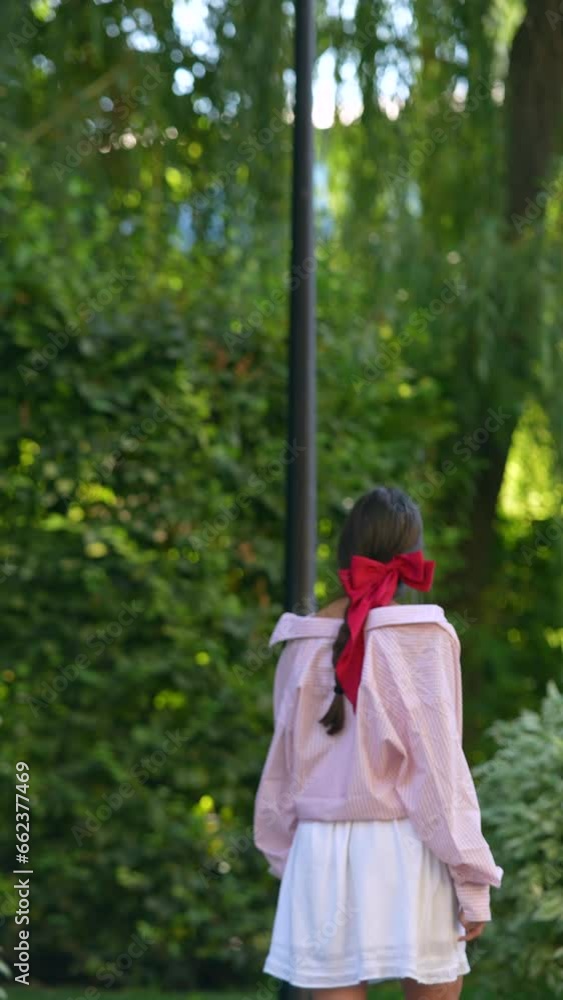 Capture of the girl from behind, showcasing a sizable bow in her hairstyle. Capture of the girl from behind, showcasing a sizable bow in her hairstyle.