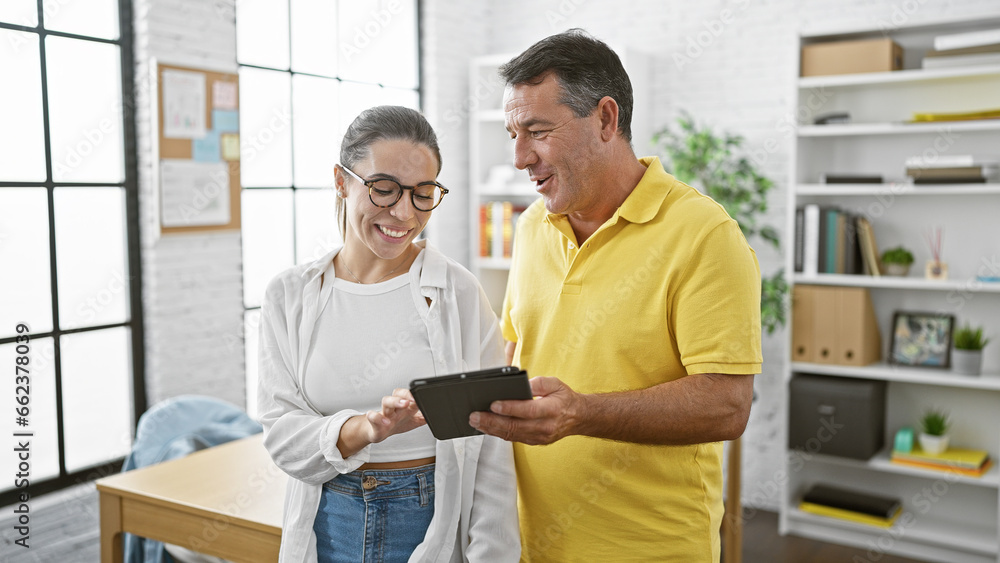 Man and woman business workers using touchpad working at the office Man and woman business workers using touchpad working at the office
