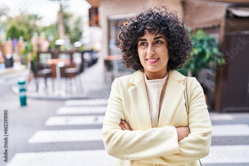 Young middle east woman excutive smiling confident standing with arms crossed gesture at street photo