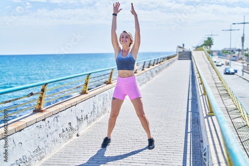 Fototapeta Naklejka Na Ścianę i Meble -  Young blonde woman wearing sportswear training at seaside