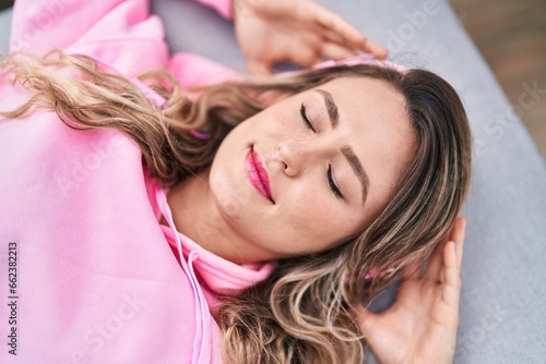 Young woman listening to music lying on sofa at home