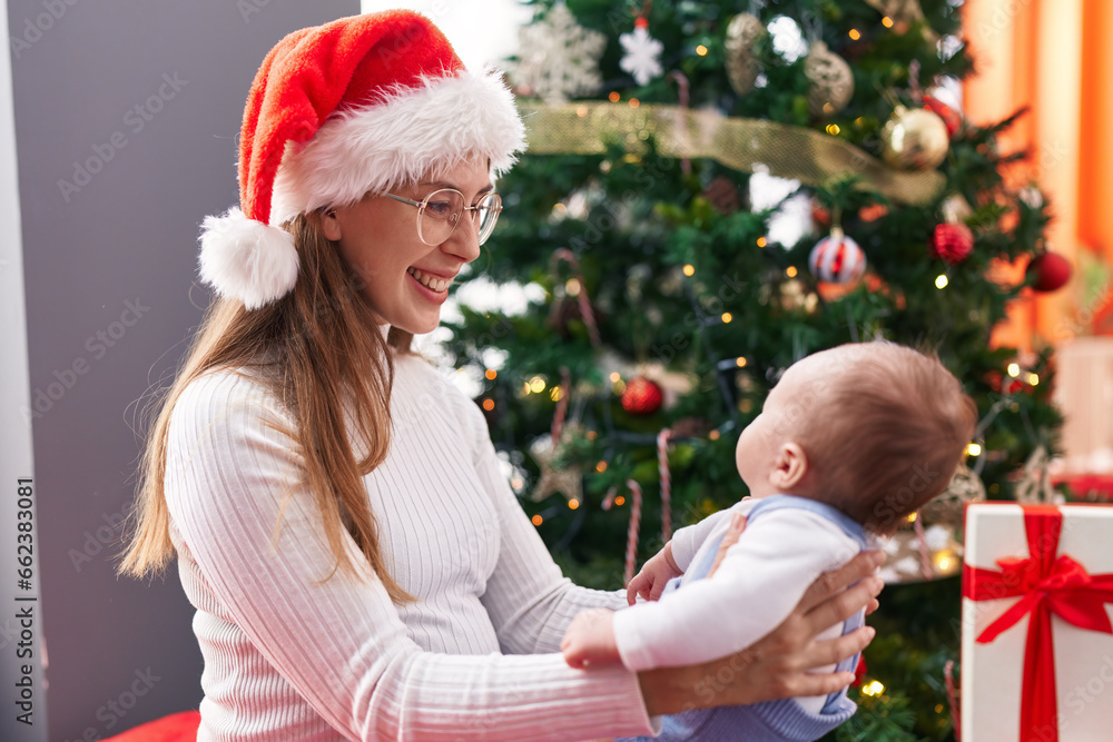 Mother and son standing by christmas tree at home Mother and son standing by christmas tree at home