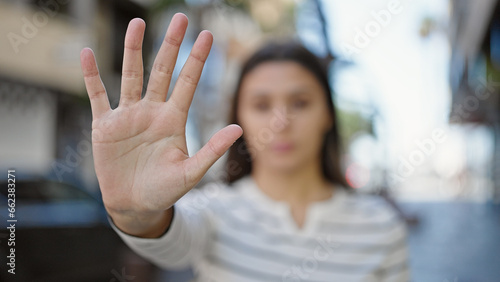 Young beautiful hispanic woman doing stop gesture with hand at street © Krakenimages.com