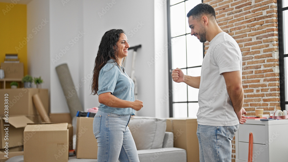 Man and woman couple playing rock scissors paper game smiling at new home Man and woman couple playing rock scissors paper game smiling at new home