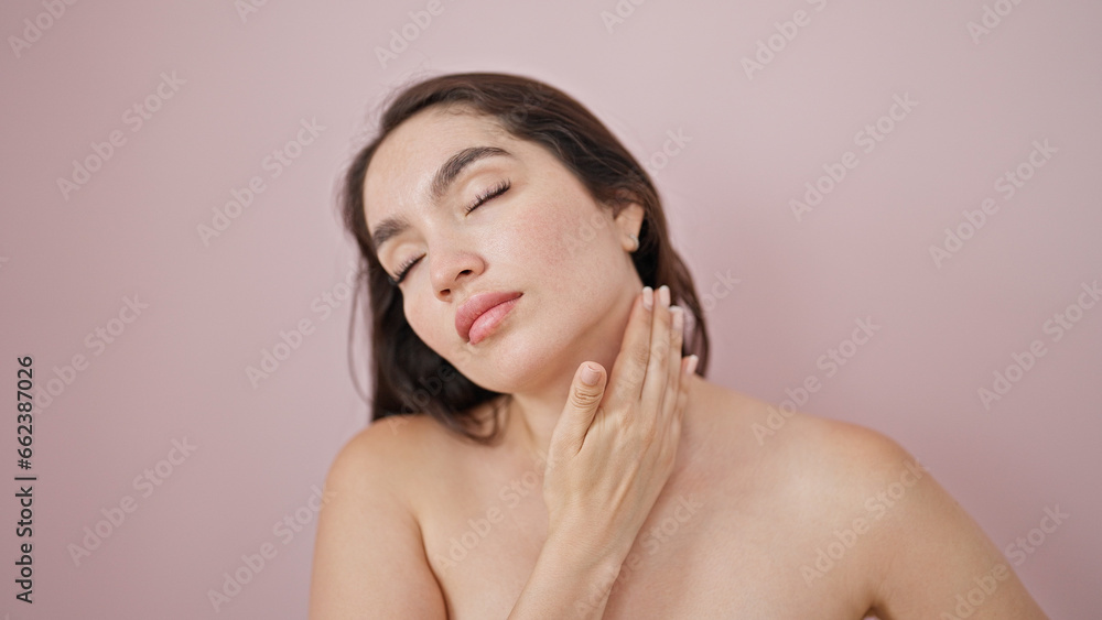 Obraz premium Young beautiful hispanic woman massaging neck over isolated pink background